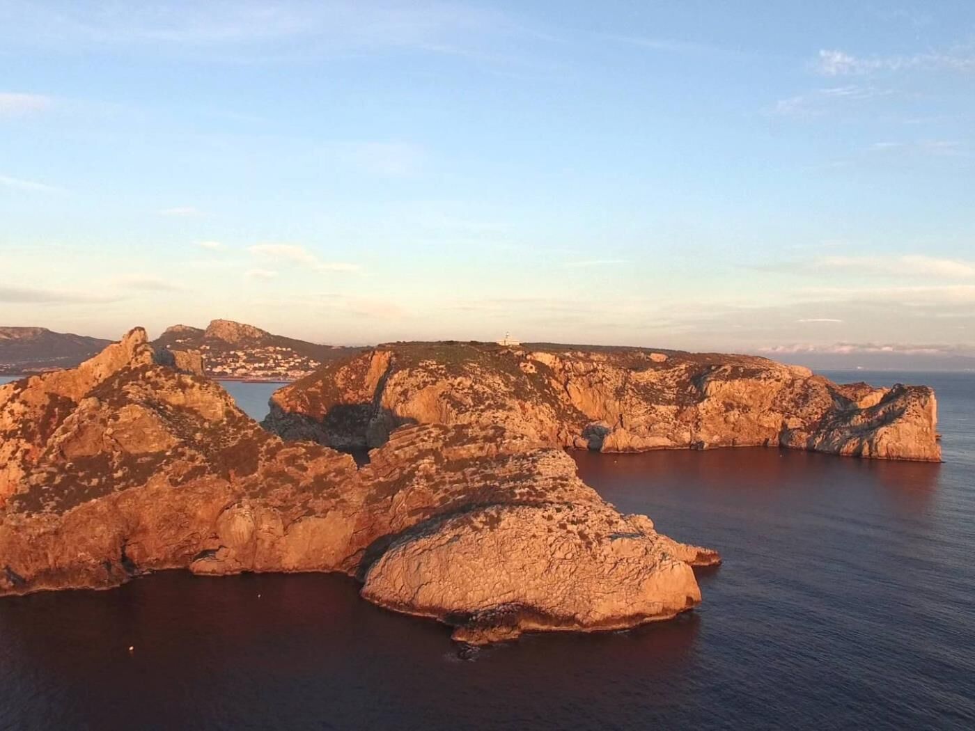 Un paysage côtier caractérisé par des formations rocheuses et une étendue d’eau.