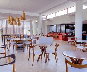 A spacious hotel lobby with multiple seating areas, a central bar, and large windows allowing natural light. - Ile de Pipa- Summer Pipa (Tibau do Sul)