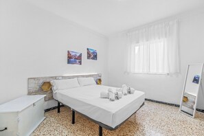 Une chambre d’hôtel avec un lit, une table de chevet, un miroir et une fenêtre avec des rideaux.