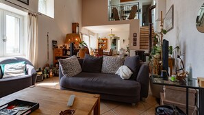 A cozy living room with a sofa, a coffee table, and a bookshelf.