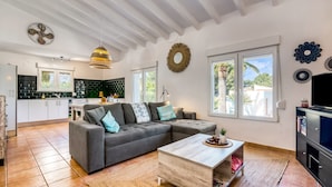 A modern living room with a sectional sofa, a coffee table, and a kitchen in the background.