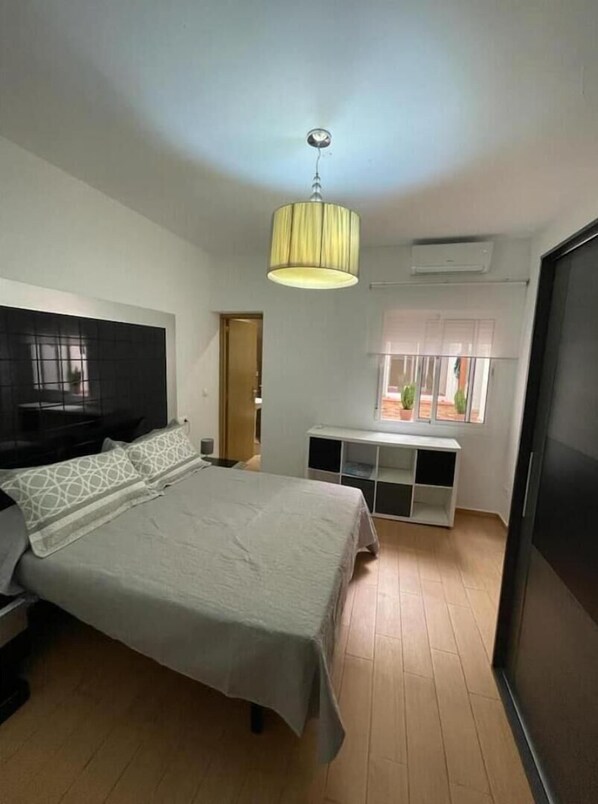 Une chambre à coucher avec un lit, une télévision, une fenêtre donnant sur un beau paysage et un luminaire au plafond.