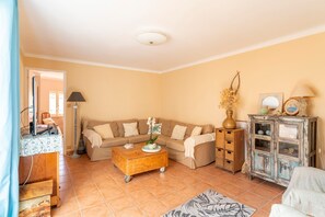 A living room with a sofa, coffee table, cabinet, and a mirror. - Maison Belle Vue: Peaceful Stay with Alpilles View in Les Angles (Les Angles)