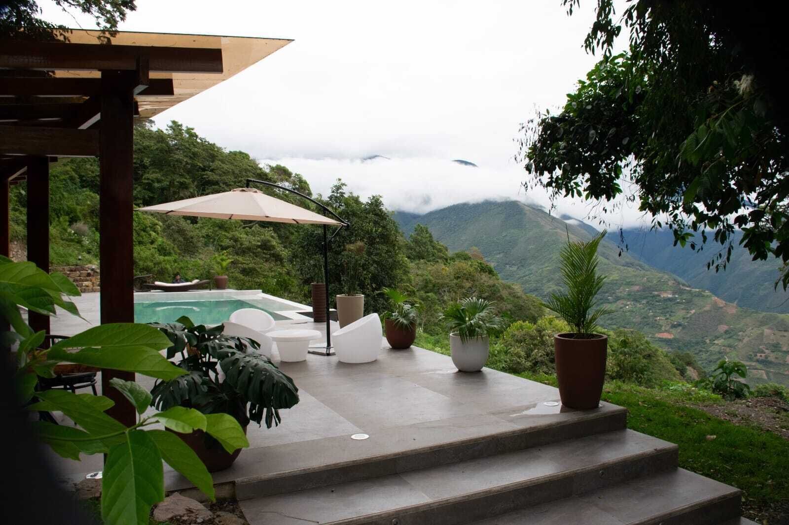 Un espace piscine avec des marches menant à une terrasse offrant une vue sur un paysage montagneux.