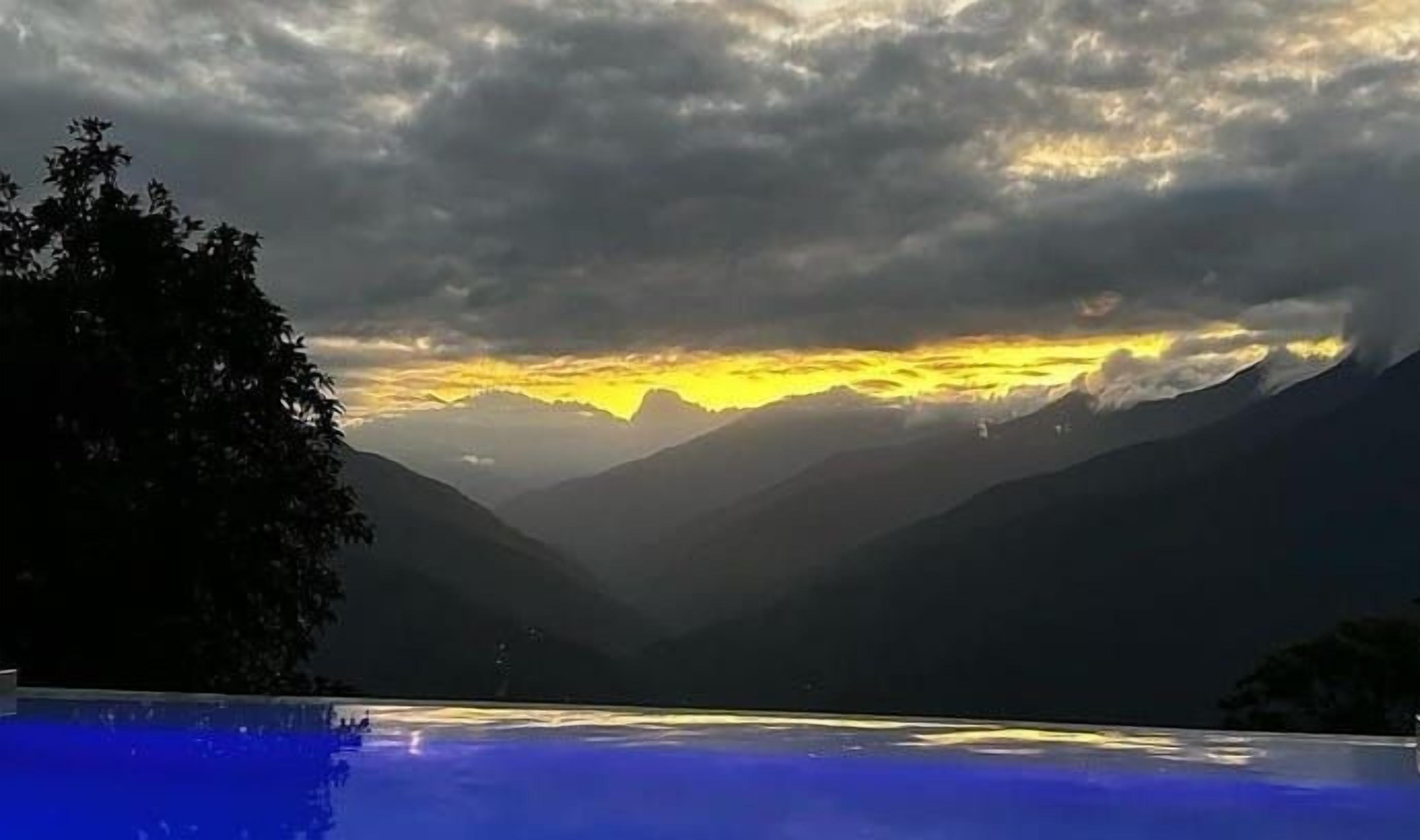 Una piscina con un paisaje montañoso al fondo.