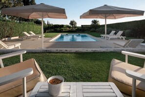Ein Poolbereich mit Liegestühlen und Sonnenschirmen.