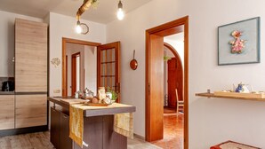 Une cuisine moderne avec des meubles en bois, un îlot central et un luminaire suspendu.