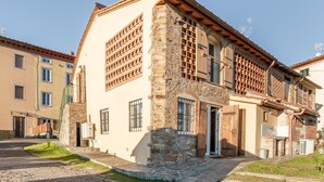 A building with a stone facade, multiple windows, and a door. - Holiday Home 'La Capanna Di Arturo Ground Floor' with Mountain View, Wi-Fi and Air Conditioning (Capannori)
