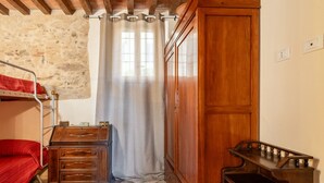 A room with a bunk bed, a wooden dresser, a cabinet, and a wooden desk. - Holiday Home 'La Capanna Di Arturo Ground Floor' with Mountain View, Wi-Fi and Air Conditioning (Capannori)