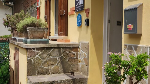 A building with a stone facade, a number 27 sign, a 'GHI Grozzolo Home' sign, and a potted plant. - Holiday Home 'Gnazzano Home 1' with Mountain View, Wi-Fi and Air Conditioning (Loiano)