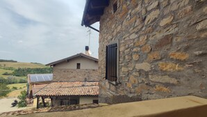 A stone building with a tiled roof, a window with shutters, and solar panels on the roof. - Holiday Home 'Gnazzano Home 1' with Mountain View, Wi-Fi and Air Conditioning (Loiano)