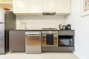 A modern kitchen with stainless steel appliances, a dishwasher, oven, and a coffee maker.