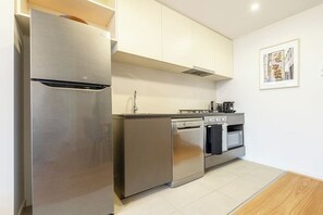 A modern kitchen with stainless steel appliances, a dishwasher, oven, and a coffee maker.