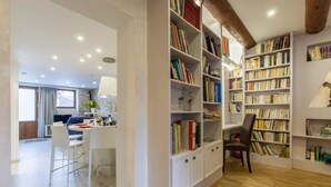 Un intérieur moderne comprenant un coin repas, une bibliothèque avec des étagères et un plafond en bois.
