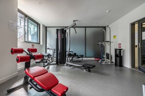 A gym with exercise equipment, a water dispenser, and a window with a view.