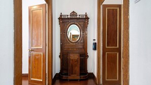 Un pasillo con puertas de madera y un espejo grande con un marco decorativo.