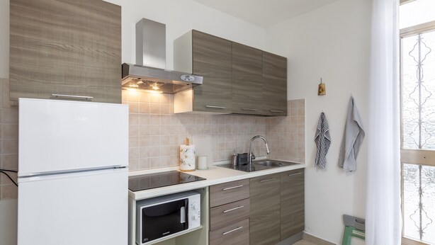A kitchen with a built-in oven, a microwave, a sink, and wooden cabinets. - Apartment 'Ca' Graziosi Cuori' with Mountain View, Shared Garden and Wi-Fi (Bagnone)