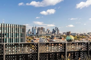 Linha do horizonte urbana com edifícios modernos, uma estrutura esférica grande e uma cerca com padrão.