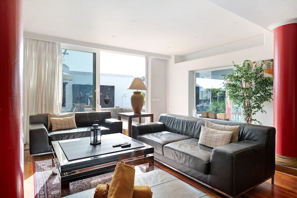 A modern living room with a sofa, coffee table, and a large window with a view.