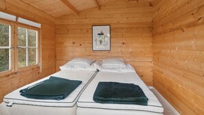 A wooden cabin room with two beds, a window, and a framed picture on the wall. - 3 bedroom beautiful home in Samsø (Samsø)