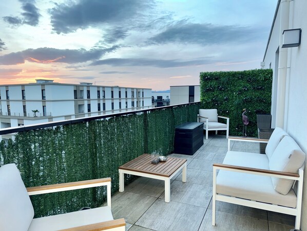 Relax on the balcony with a view, surrounded by lush greenery and a decorative touch.