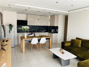 Cozy living space with a dining area, comfortable sofa, and modern kitchen.