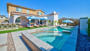 A modern house with a swimming pool, outdoor seating, and a well-maintained lawn. - Los Arcos- 7 bedrooom, sleeps 19 Pool Home (Coachella)