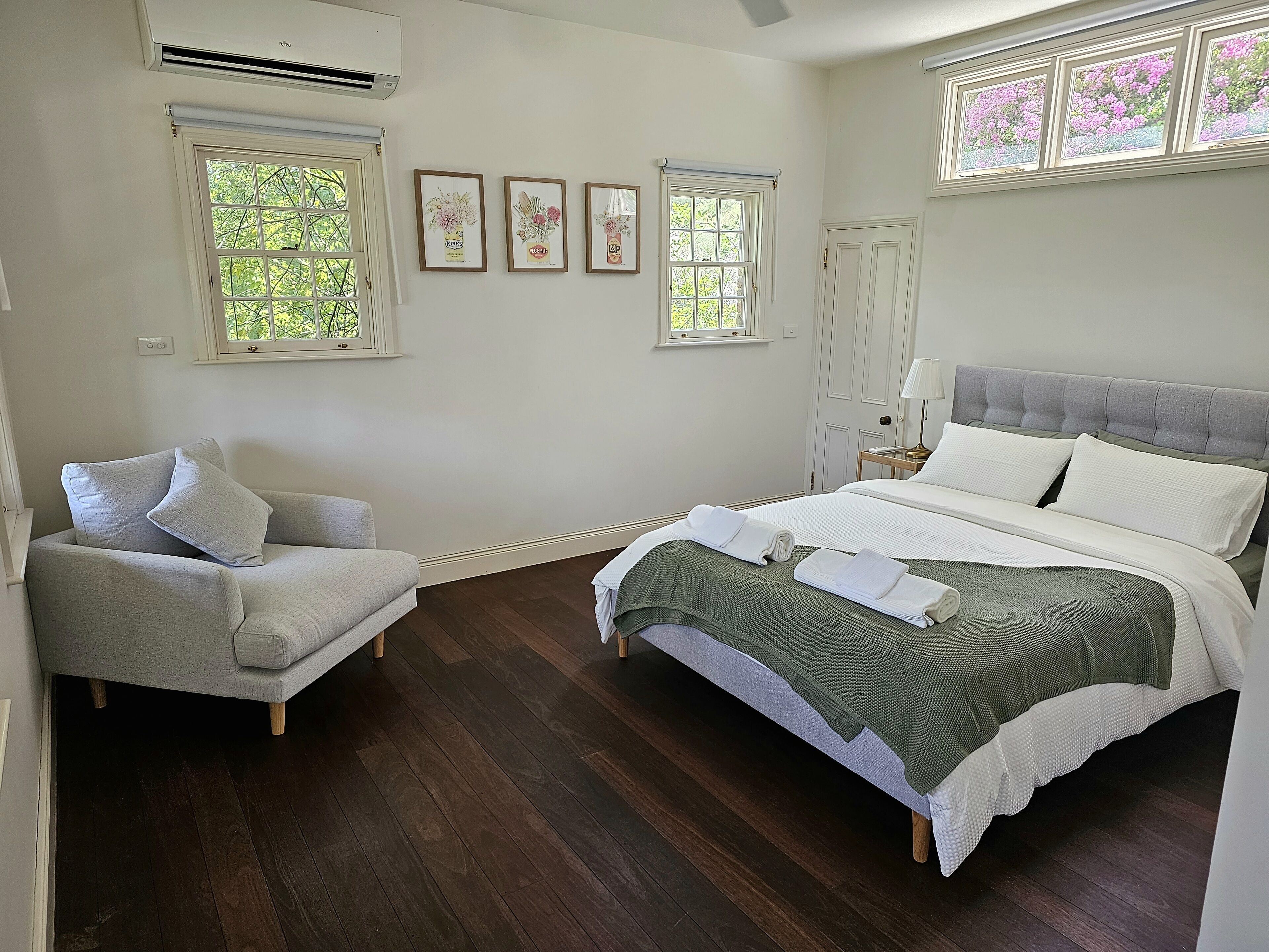Une chambre à coucher avec un lit, une chaise et une fenêtre.