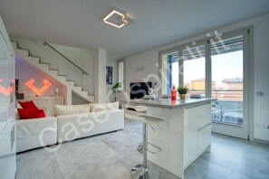 A modern apartment with a staircase, a white sofa, a kitchen island, and a balcony with a view. - Casa La Perla is a classy residence in Cernusco sul Naviglio, ideal for a couple. Located on the elegant second floor of an elevator-accessible building, the bright living room welcomes you for relaxing moments. The modern kitchen is fully equipped. A co (Cernusco sul Naviglio)