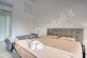 Quarto de hotel com cama, mesa de cabeceira e janela.