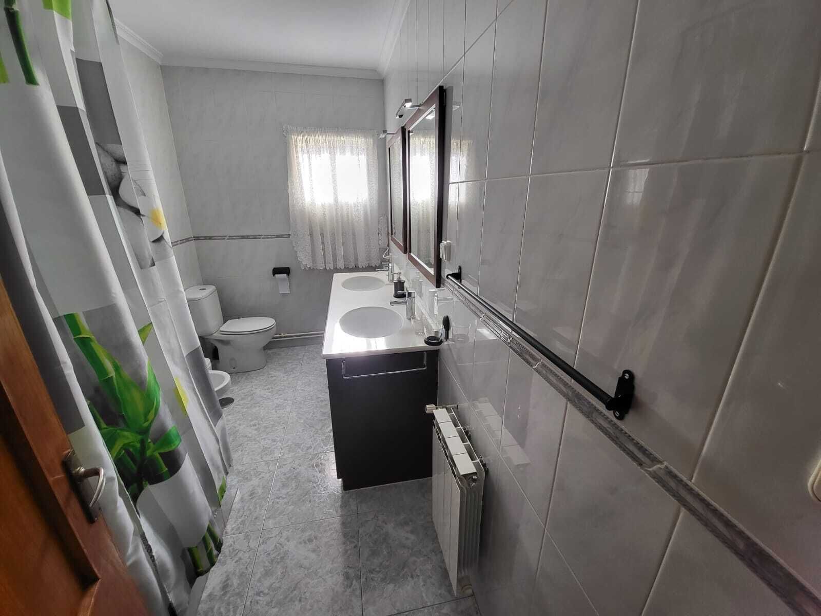 Un baño con inodoro, lavamanos y espejo.