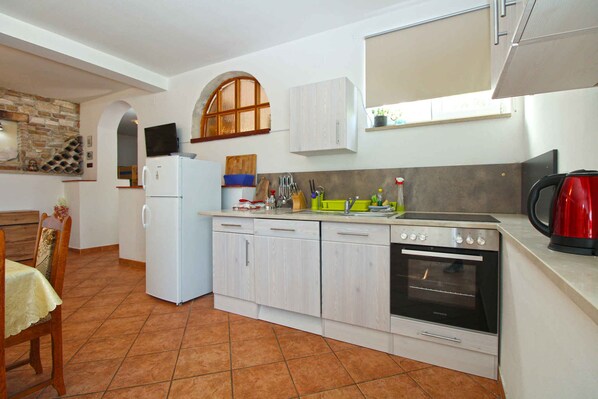 Réfrigérateur, un four, surface de cuisson, vaisselle et ustensiles