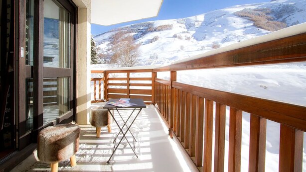 A balcony with a wooden railing, a small table, and a chair. - Près du Télémixte du Diable |  T2 moderne + vue (Les Deux Alpes)