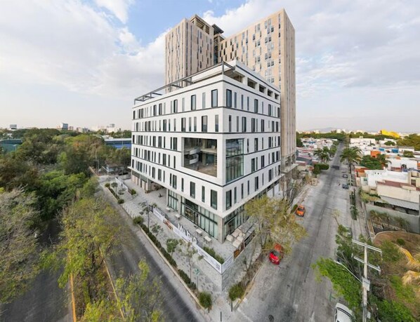 A modern multi-story building with a unique angular design, featuring large windows and a flat roof.
