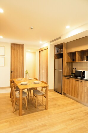 A modern kitchen with wooden cabinets, a built-in microwave, and a refrigerator.