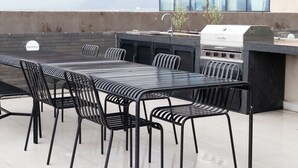 An outdoor dining area with a grill and seating. - Margot. Expo (Guadalajara)