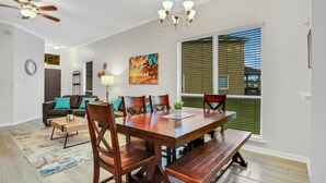 A dining area with a wooden table, chairs, and a bench. There is a ceiling fan, a chandelier, and a painting on the wall. - ~Spacious 4/2 in Oakleaf, pet friendly (Orange Park)
