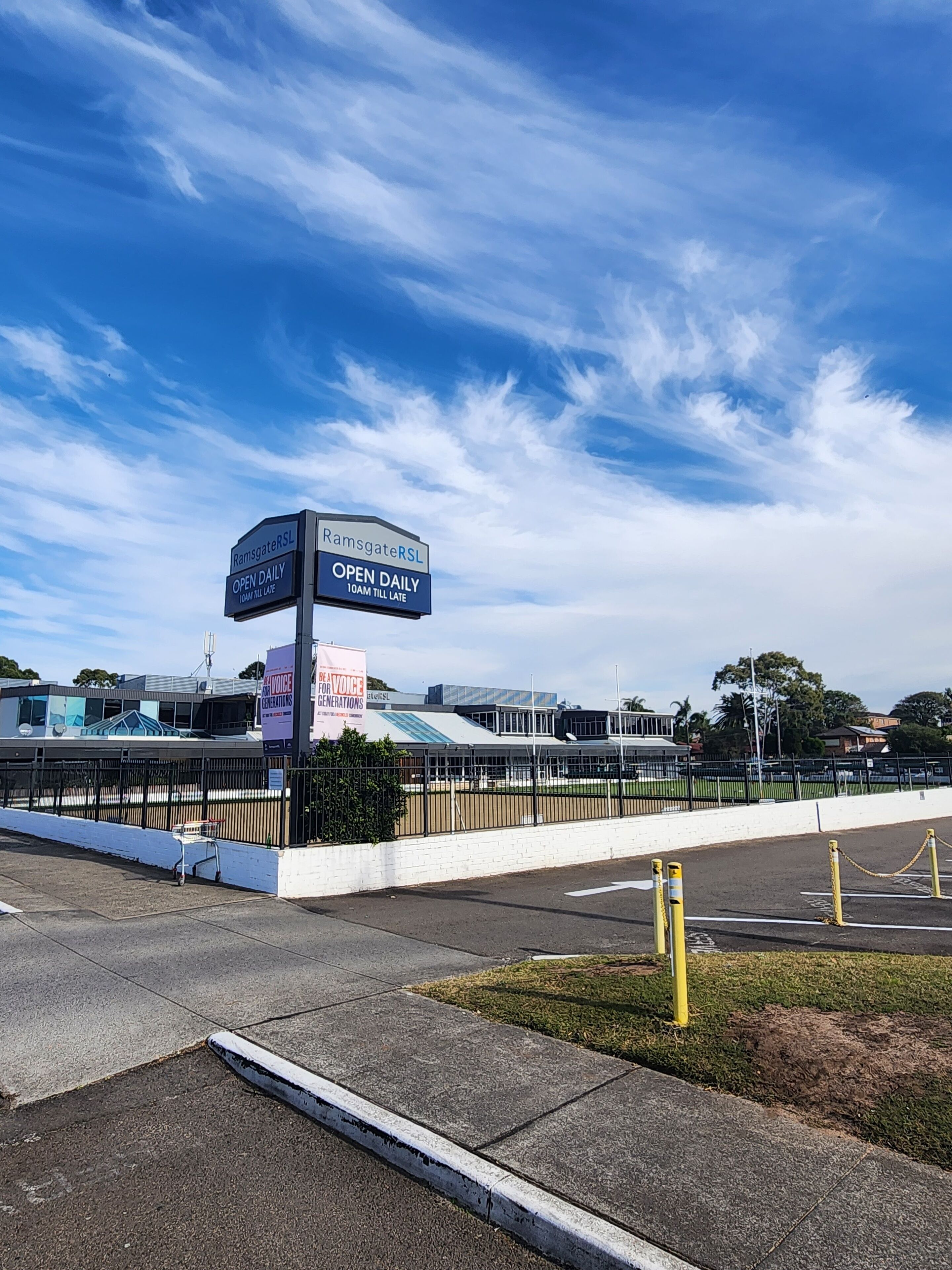 Een parkeerplaats met een bord waarop 'RamsgateRSL OPEN DAILY 10AM TILL LATE' staat.