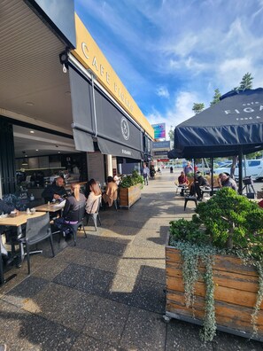 An outdoor café with tables and chairs, a sign for 'Figaro', and a 'Hairloss' establishment in the background. - 'Peaceful Getaway' (Ramsgate)