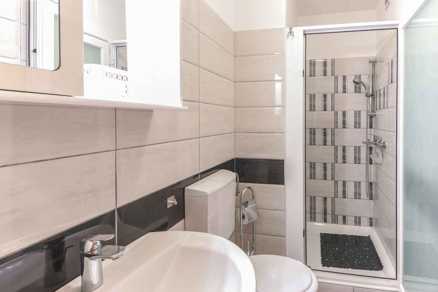 Une salle de bain moderne équipée d’une douche, de toilettes et d’un lavabo.