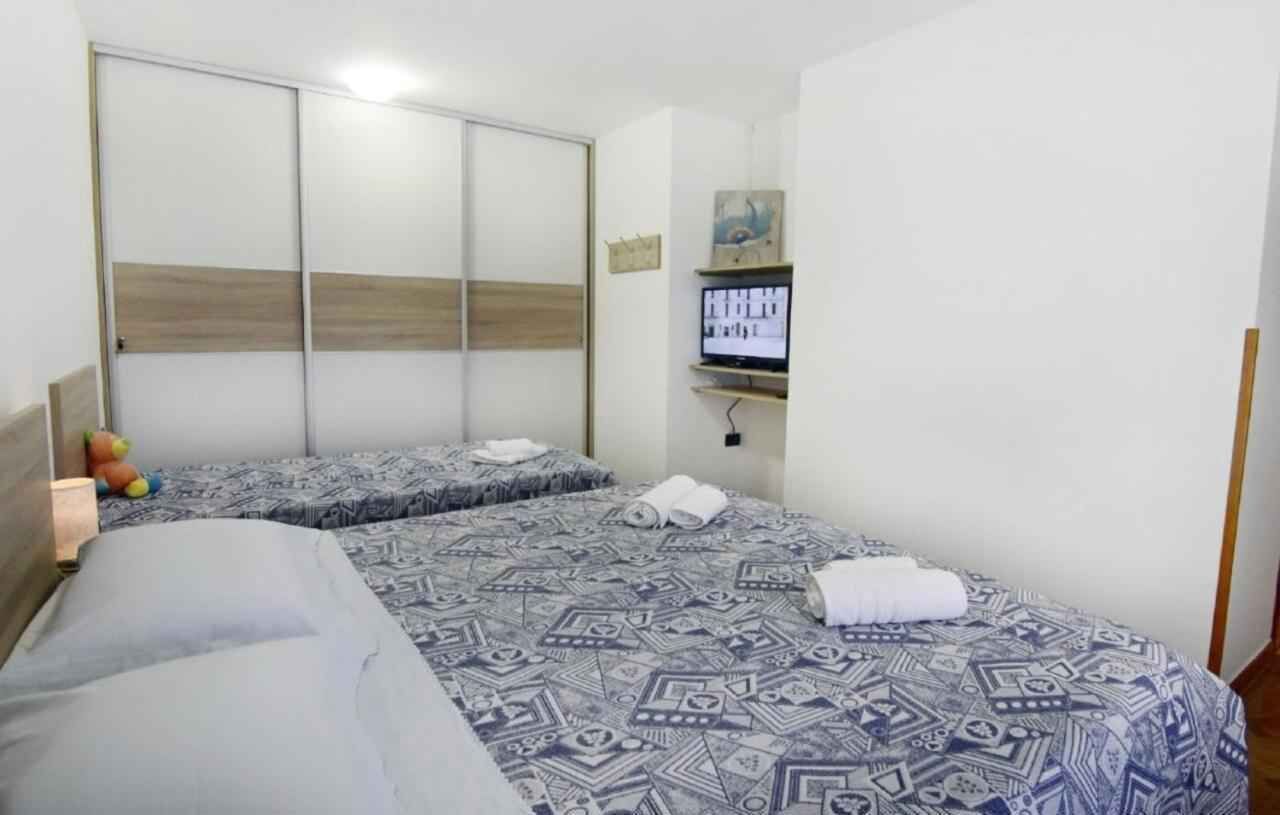 Una habitación de hotel con dos camas, un televisor y un armario.