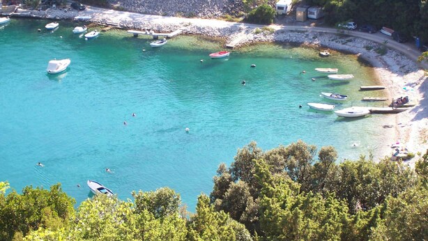 Una zona costera con barcos amarrados a la orilla y una vista despejada de la playa.