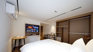 A hotel room with a bed, a desk, a TV, and a wardrobe. - LN Residece Taojin (Guangzhou)