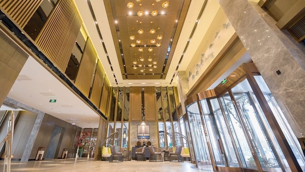 A spacious lobby with a high ceiling, modern lighting fixtures, and large windows. - LN Residece Taojin (Guangzhou)