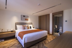 A modern hotel room with a large bed, a wooden floor, a wardrobe, a shower area, and a desk. - LN Residece Taojin (Guangzhou)