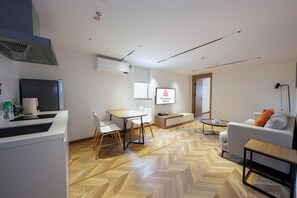 A modern living room with a sofa, a coffee table, and a dining area with chairs and a table. - LN Residece Taojin (Guangzhou)