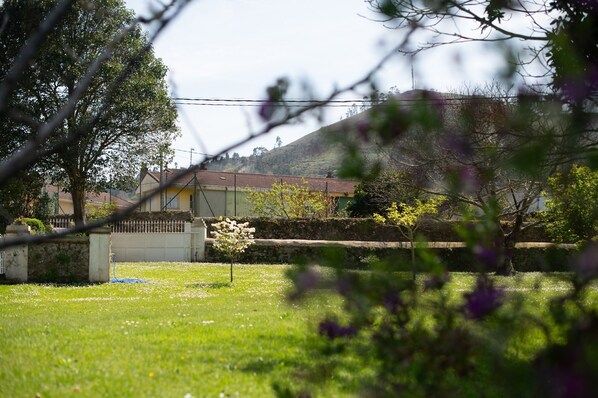 Un quartier résidentiel comprenant une maison, un mur de pierre et un champ d’herbe.