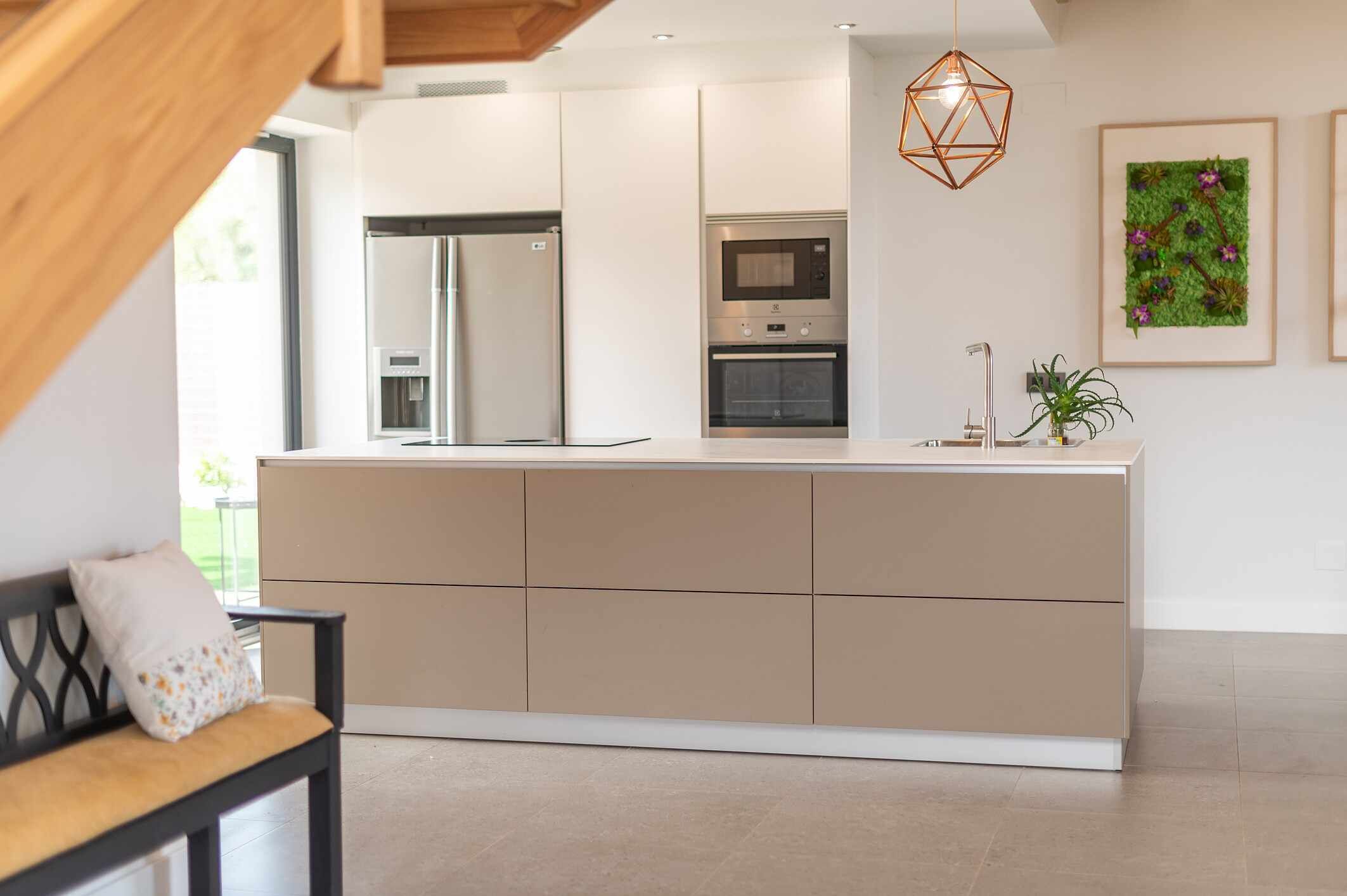 A modern kitchen with a central island, stainless steel appliances, and a pendant light.