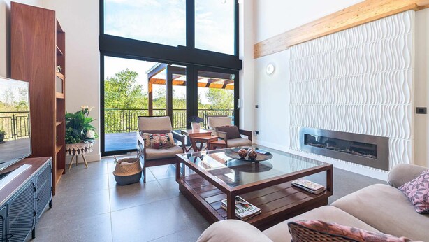 A spacious living room with a fireplace, large windows, and a balcony. - Villa Vacacional La Raizona (Pancar)