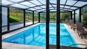 A glass-enclosed swimming pool with clear views of a green landscape. - Villa Vacacional La Raizona (Pancar)